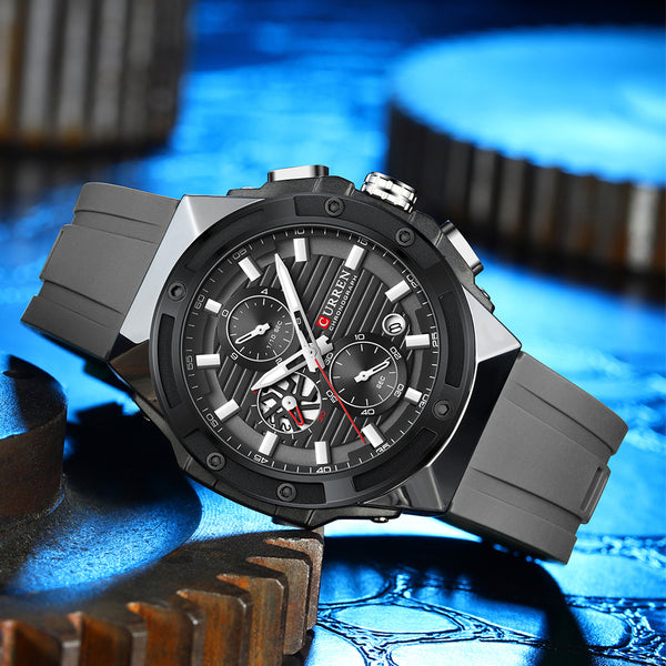 Black and gray wristwatch with detailed face on a blue mechanical gear background